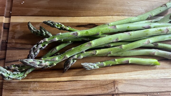 Fresh green asparagus spears on a wooden cutting board